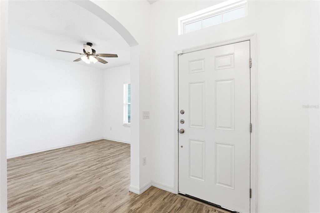 An empty bedroom features white walls, gray carpet, a ceiling fan, and a single window — 242 HERITAGE ST STREET SW, PALM BAY, FL