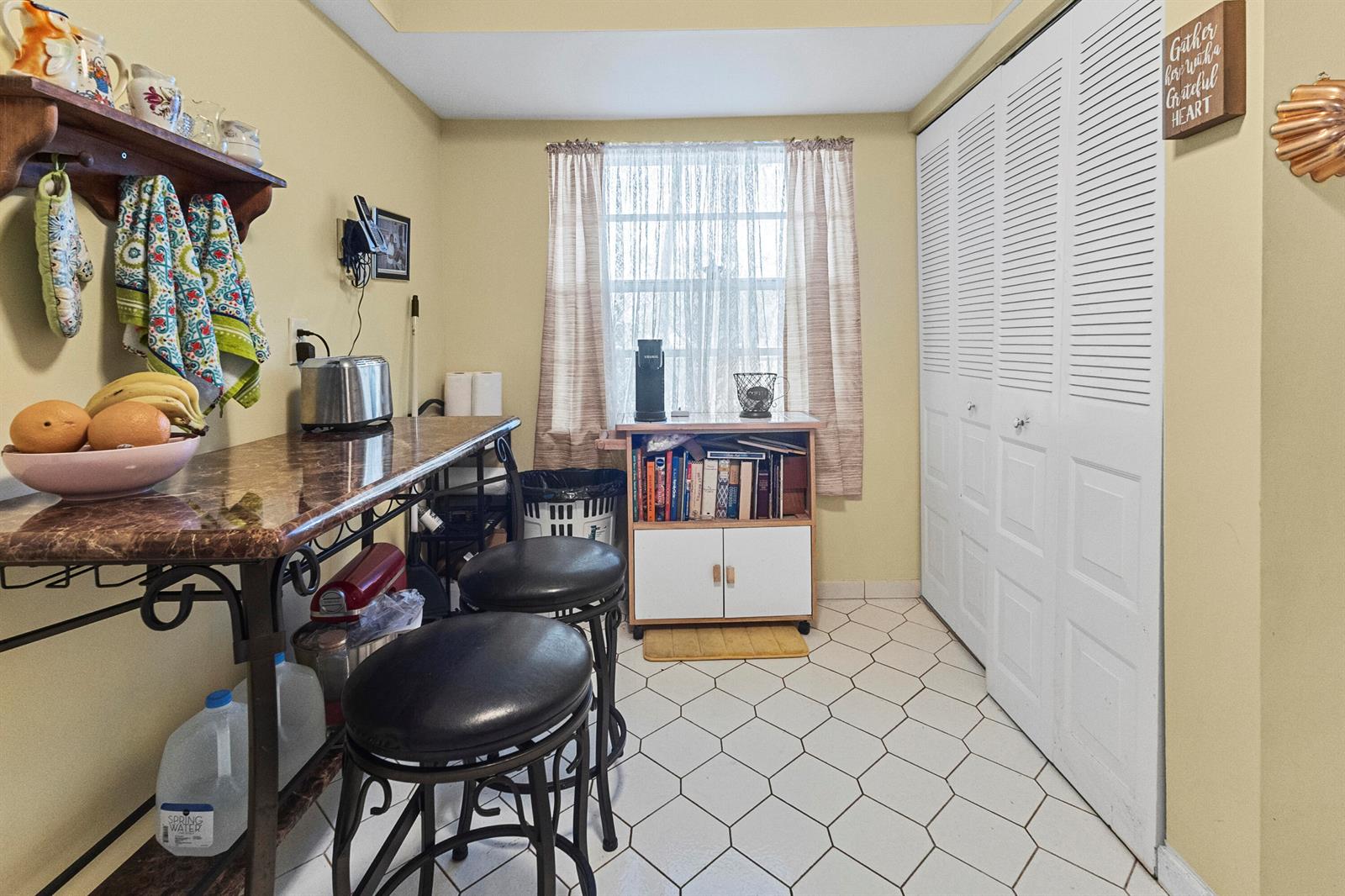 A small kitchen area features a marble-topped breakfast bar, two stools, and white louvered closet doors — 1470 NW 80th Avenue # 204, Margate FL 33063, MARGATE, FL