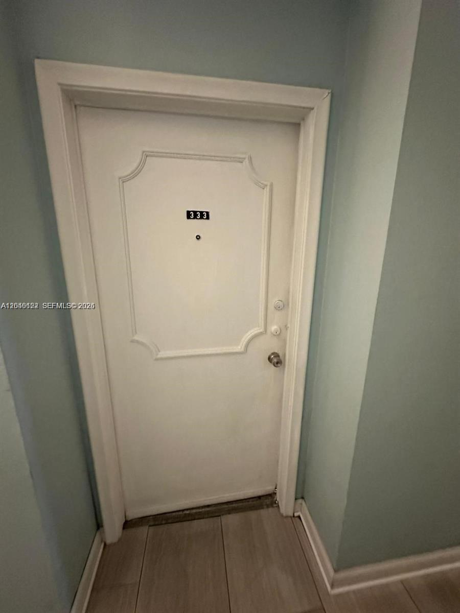 A white interior door with the number 333 is set against light blue walls — HALLANDALE BEACH, FL