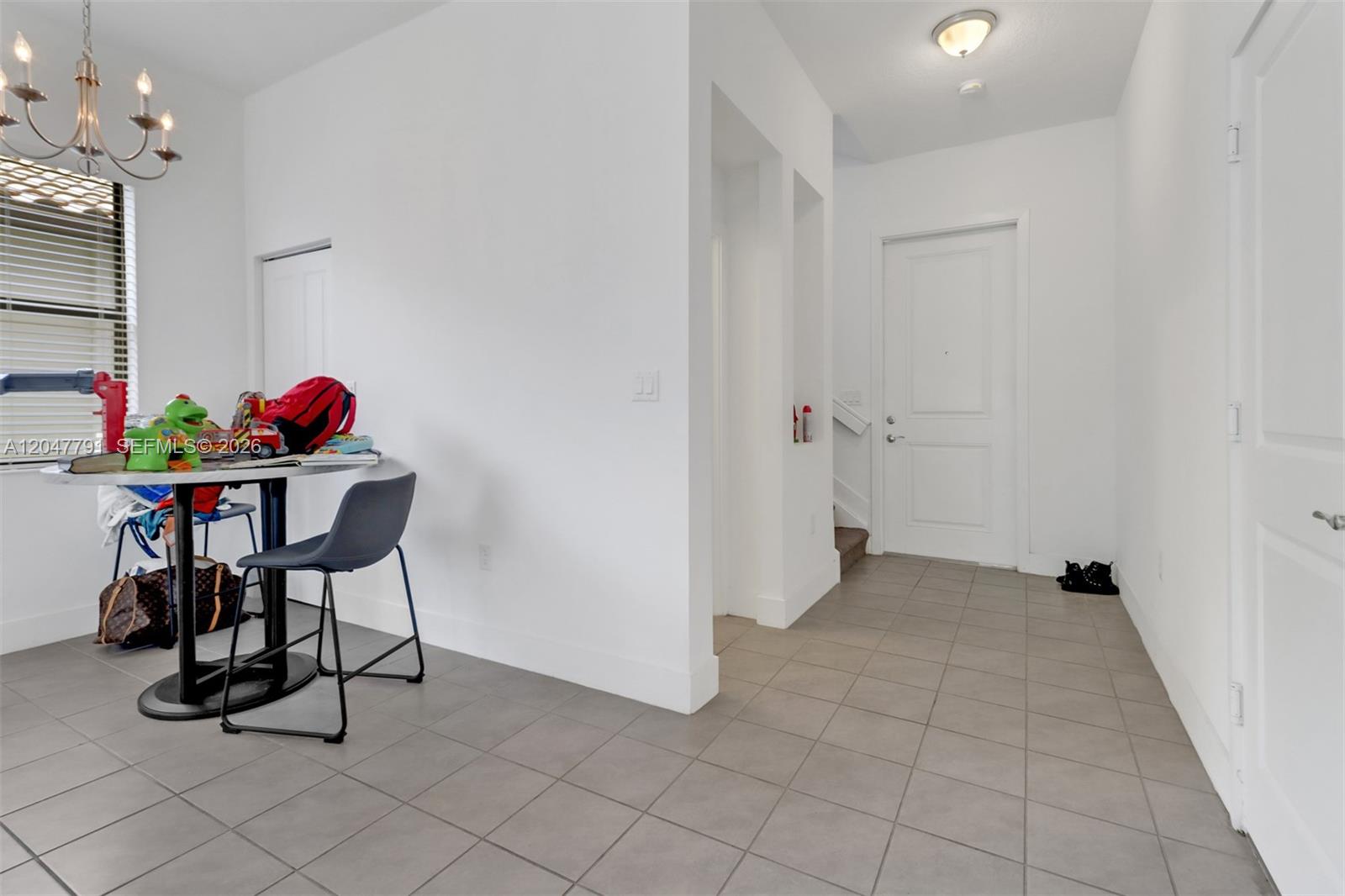 A dining area with a table and chairs leads into an entryway with tiled floors — 5504 Agostino Way, Ave Maria FL 34142, AVE MARIA, FL