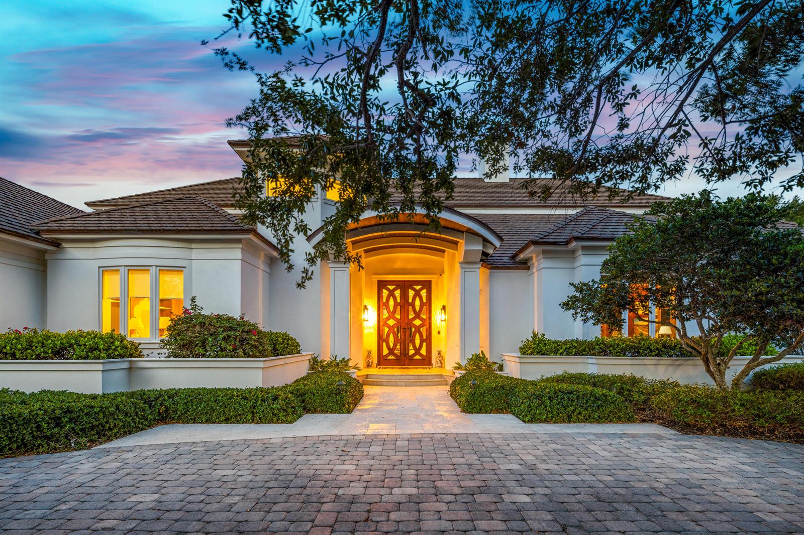 A white house with a paved driveway and a decorative wooden double front door — 17965 SE Village Circle, Jupiter FL 33469, JUPITER, FL
