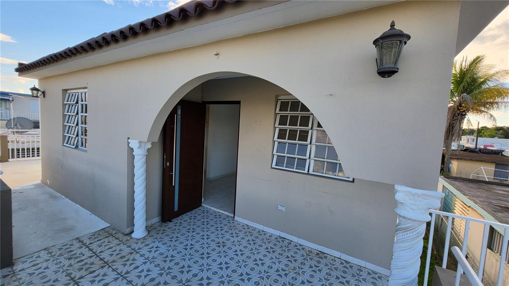 A covered patio features patterned tile flooring, two decorative white columns, and an arched entryway — CALLE 6, G-27 URB FRANCISCO OLLER UNIT 2, BAYAMON, PR
