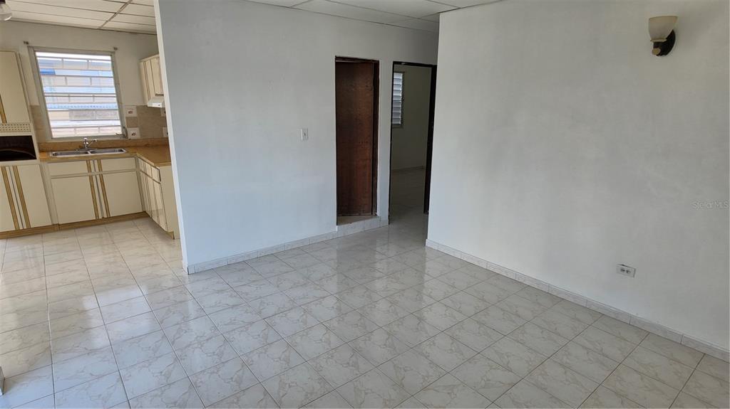An interior view shows a tiled kitchen area adjacent to a living space with doorways — CALLE 6, G-27 URB FRANCISCO OLLER UNIT 2, BAYAMON, PR