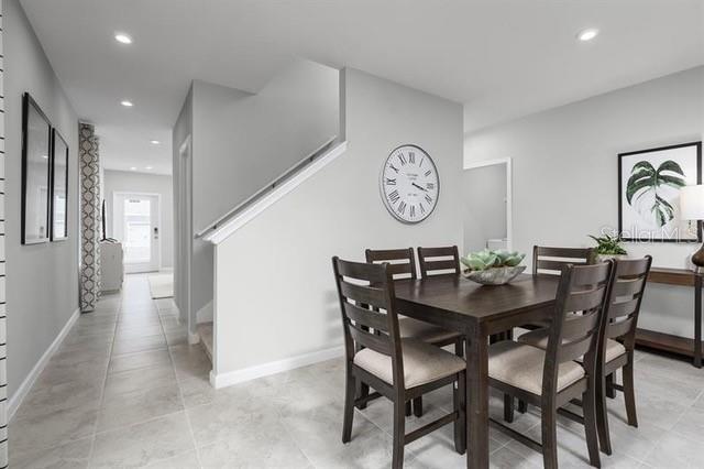 A modern kitchen features white cabinets, granite countertops, stainless steel appliances, and a breakfast bar — 12316 GRIZZLY LANE, NEW PORT RICHEY, FL