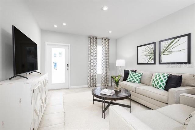 A dining area with a dark wood table and chairs sits beside a staircase — 12316 GRIZZLY LANE, NEW PORT RICHEY, FL