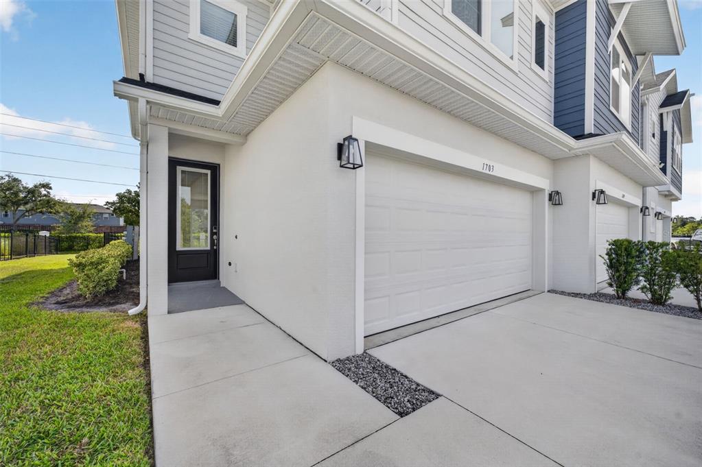 A side-entry door and a white garage door are visible on the exterior of a townhouse — 1703 TERRAPIN ROAD, OCOEE, FL