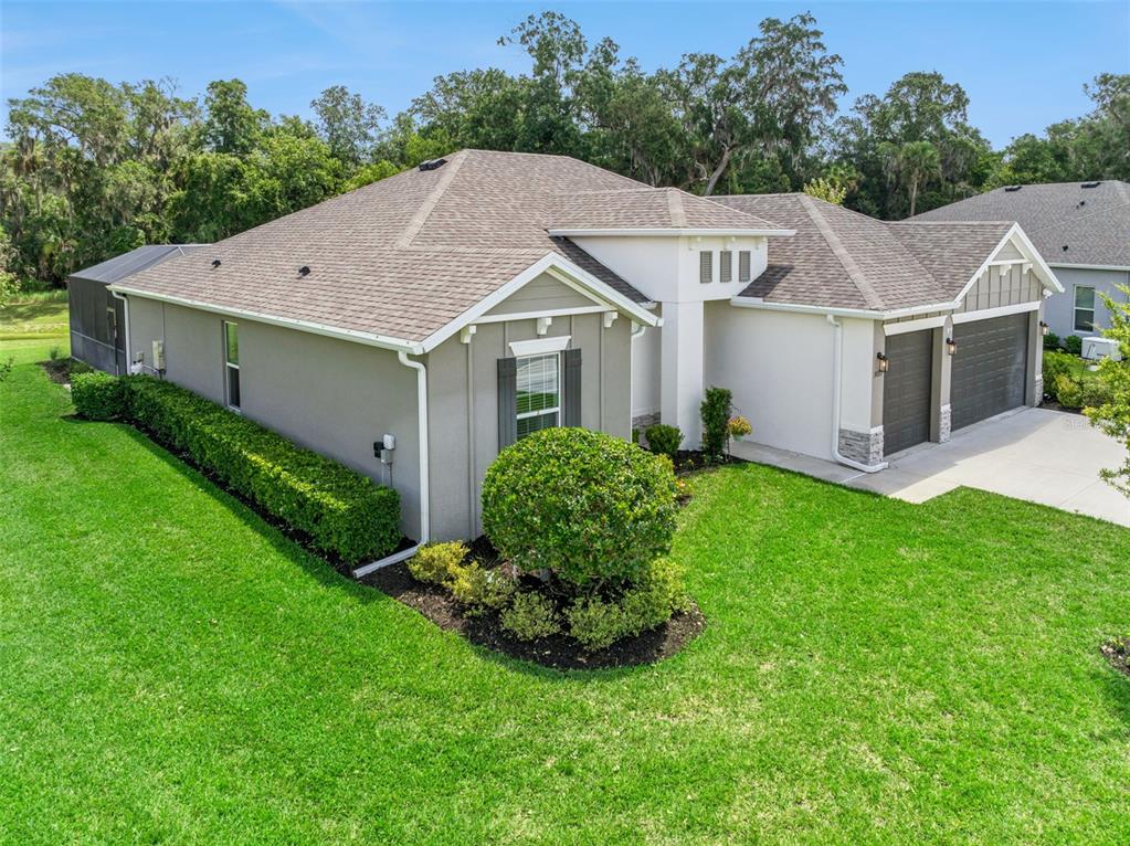 An exterior view of a single-story house with a gray stucco facade and two-car garage — 3093 ADRIAN DR, ORMOND BEACH, FL