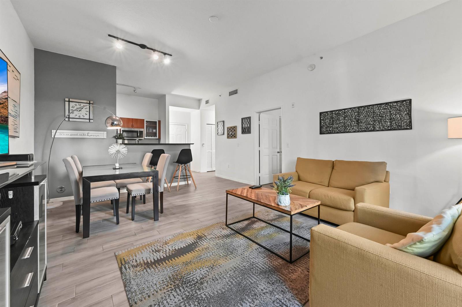 A living room and dining area with light wood floors, neutral walls, and modern furniture — 804 E Windward Way # 122, Lantana FL 33462, LANTANA, FL