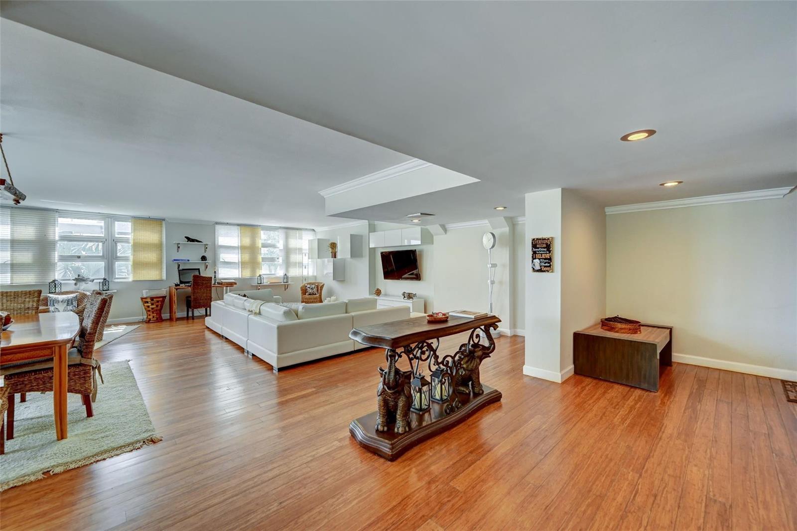 A spacious living area features hardwood floors, a white sectional sofa, and an elephant-themed console table — 525 N Ocean Boulevard # 2, Pompano Beach FL 33062, POMPANO BEACH, FL