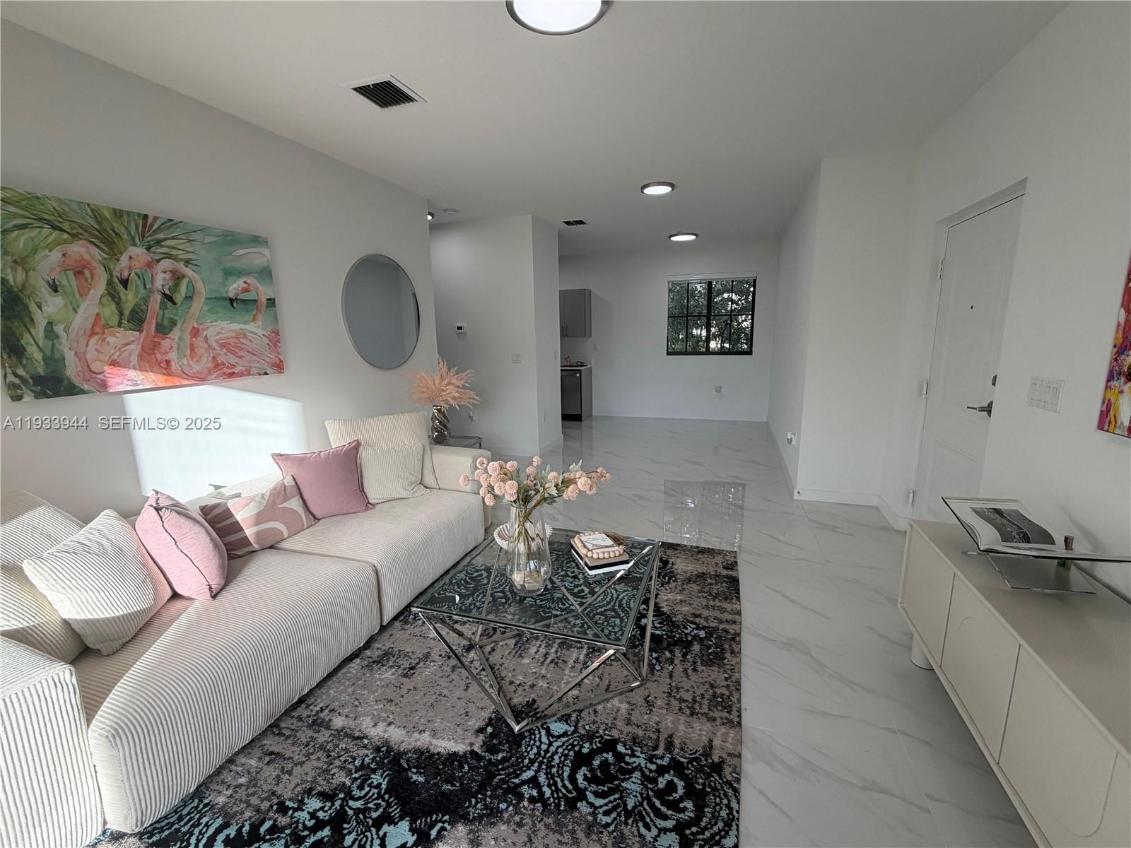 A living room features a striped sofa, glass coffee table, and white marble-look tile flooring — 2306 E 4th ave # 303, Hialeah FL 33013, HIALEAH, FL