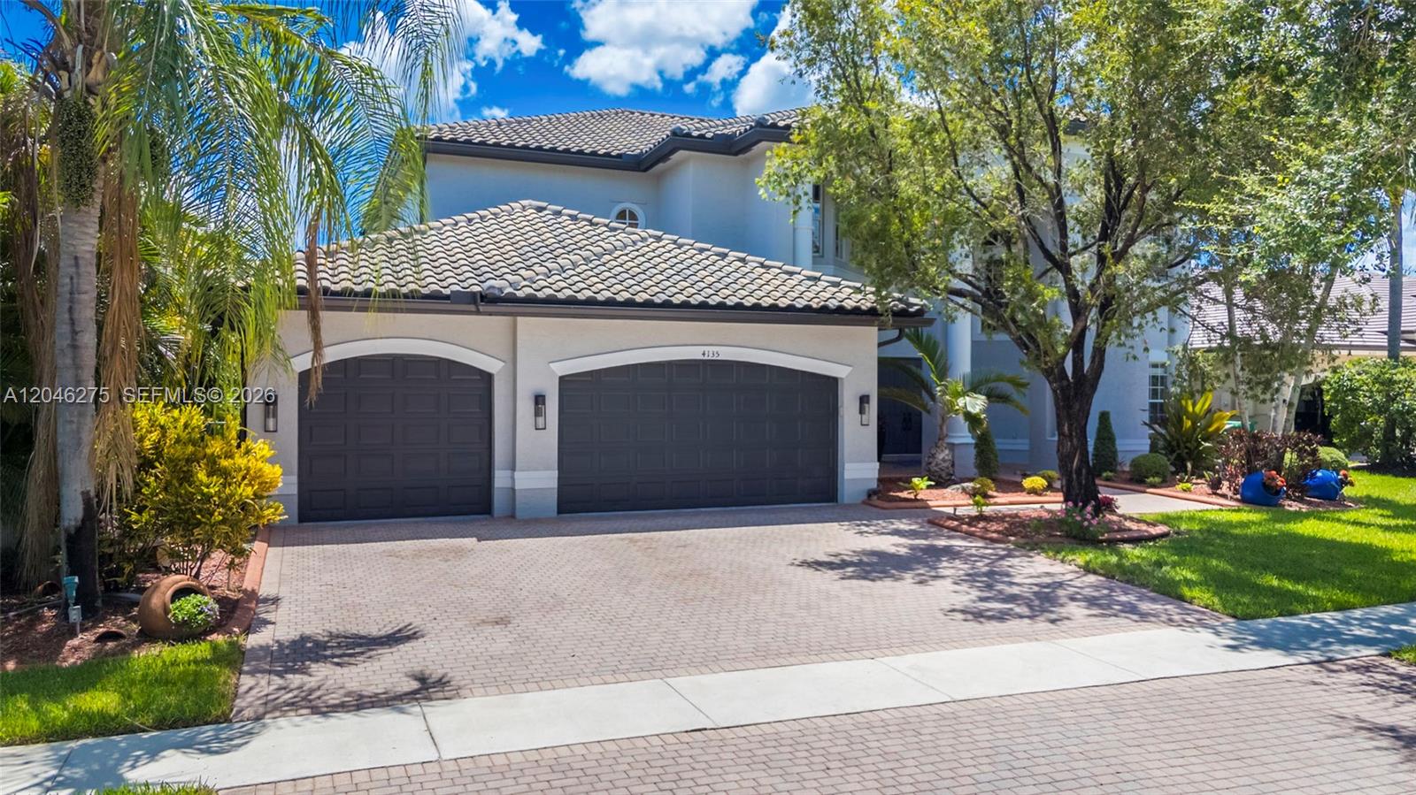 A two-story house features a three-car garage, a paver driveway, and mature landscaping — 4135 SW 186th Way, Miramar FL 33029, MIRAMAR, FL