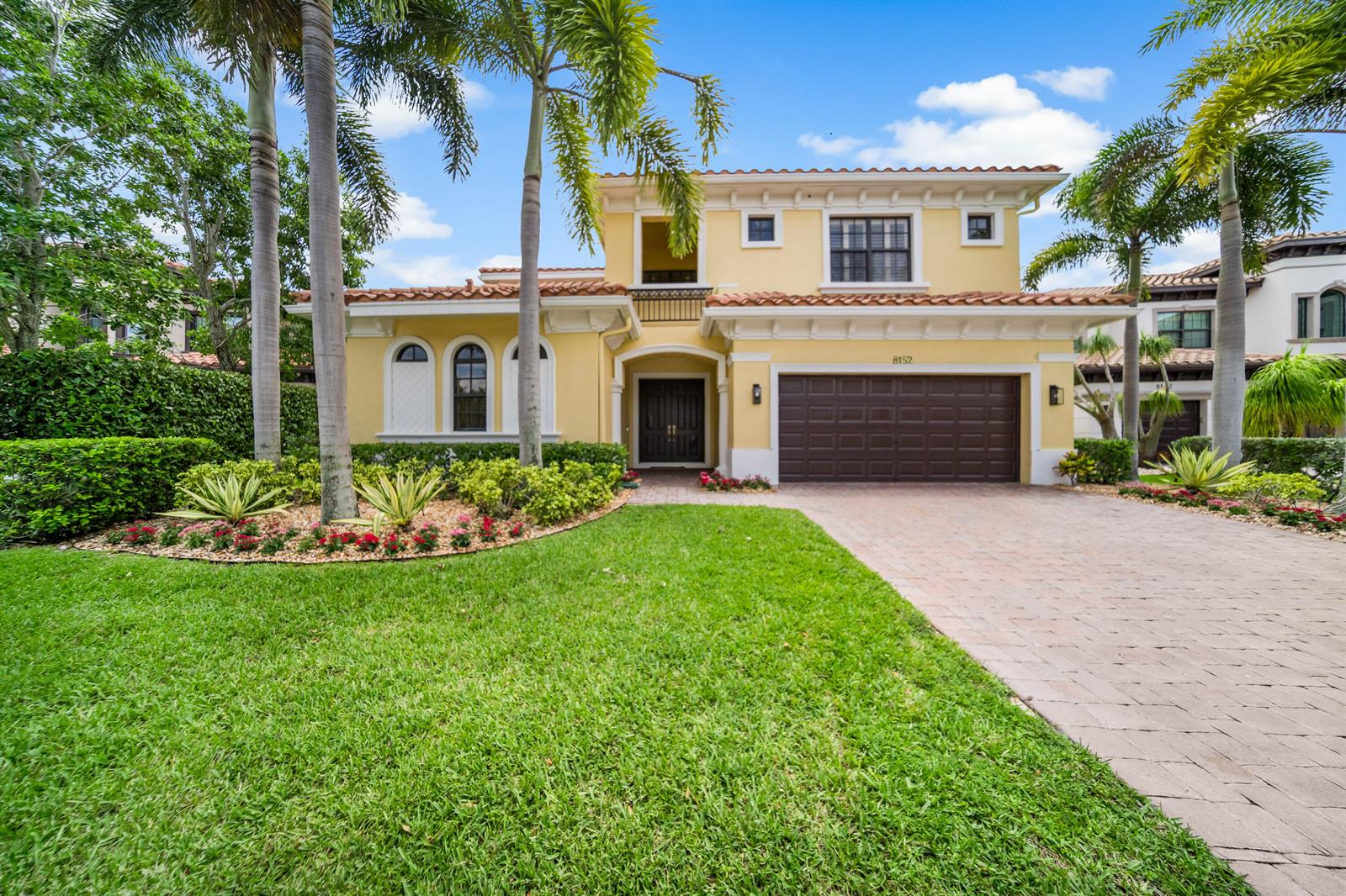A two-story yellow house with a tile roof, palm trees, and a paved driveway — 8152 Bradford Way, Parkland FL 33076, PARKLAND, FL