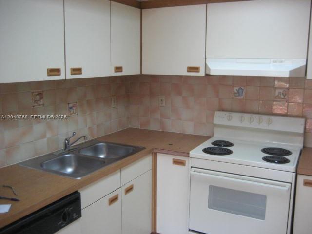 A kitchen features white cabinets, a double sink, and a white electric stove — 9022 SW 123rd Ct # O303, Miami FL 33186, MIAMI, FL