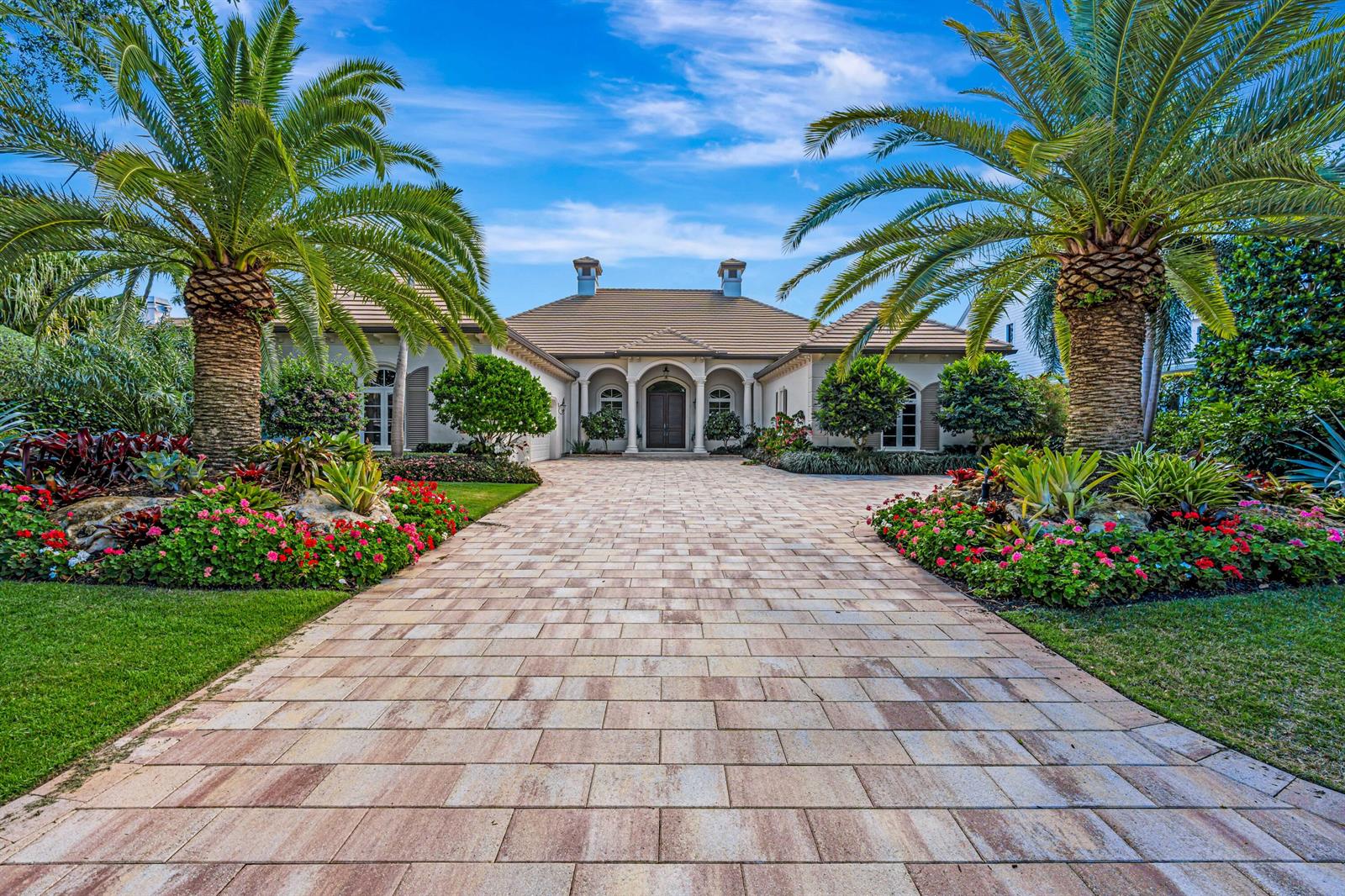 A paved driveway leads to the front entrance of a single-story house with palm trees — 469 Mariner Drive, Jupiter FL 33477, JUPITER, FL