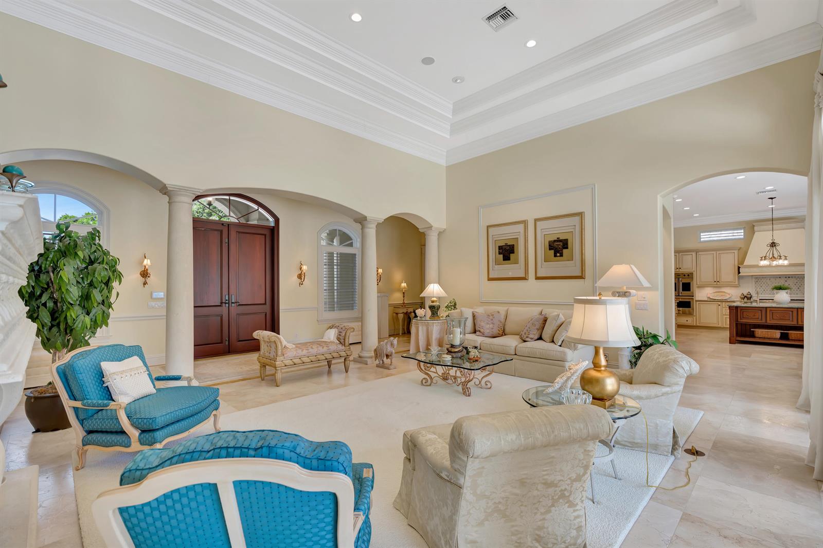 A spacious living room features high tray ceilings, arched entryways, and a neutral color palette — 469 Mariner Drive, Jupiter FL 33477, JUPITER, FL