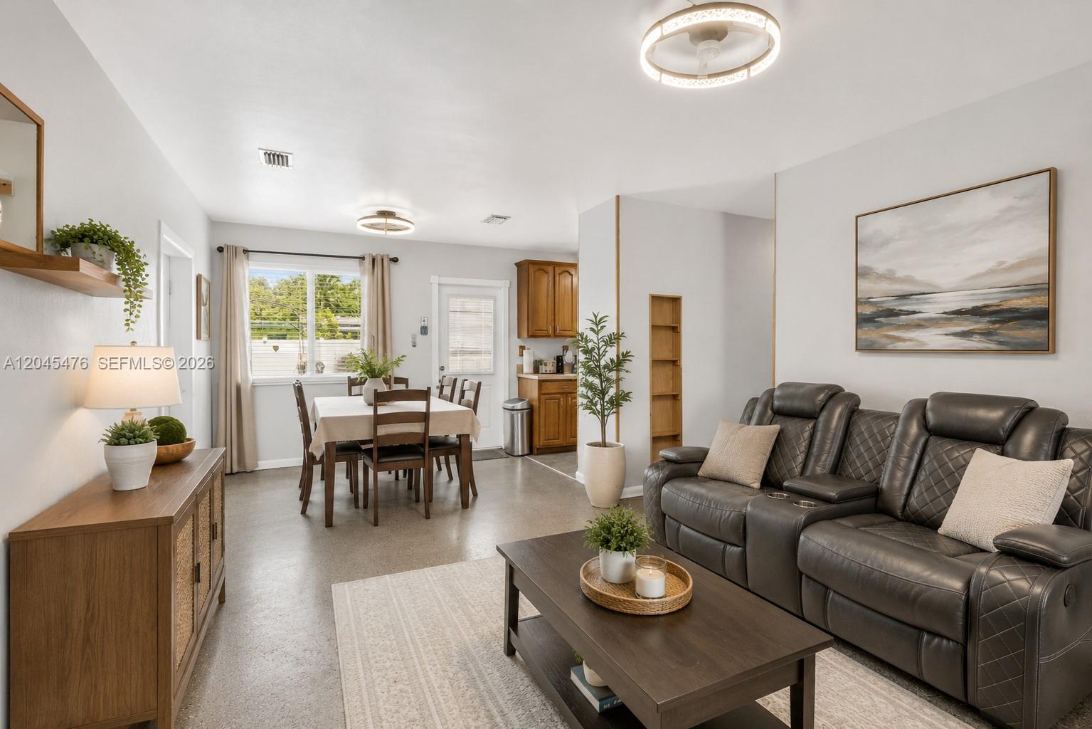 A living room and dining area feature gray leather seating, wood furniture, and tile floors — 7331 Garfield St, Hollywood FL 33024, HOLLYWOOD, FL