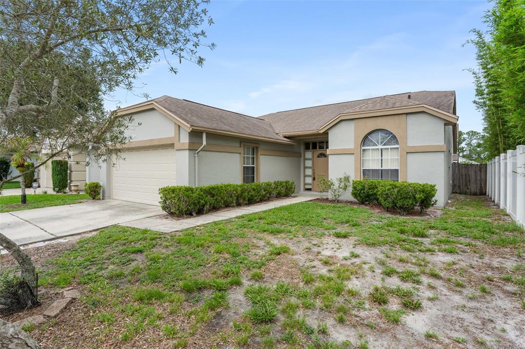 A single-story house with a beige stucco exterior, a two-car garage, and a front lawn — 796 MINERVA LANE, LAKE MARY, FL