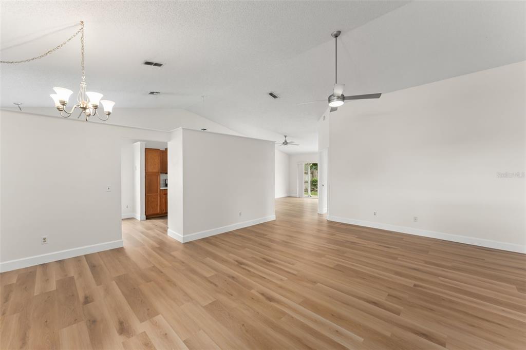 A spacious living area features light wood-look flooring, vaulted ceilings, and a modern ceiling fan — 796 MINERVA LANE, LAKE MARY, FL