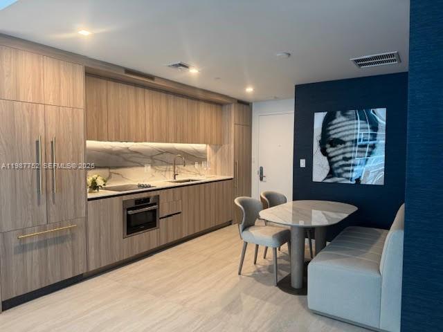 A modern living room features a light gray sofa, a round coffee table, and dining area — 77 SE 5th St # 2708, Miami FL 33131, MIAMI, FL