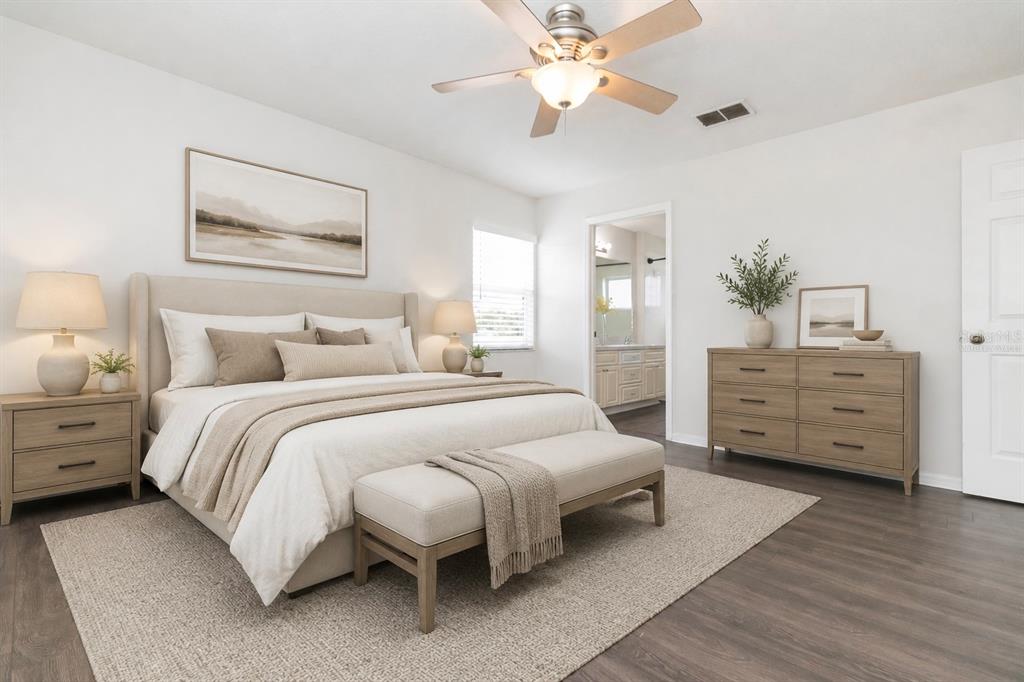 A bedroom features a bed with a beige headboard, a wooden dresser, and a ceiling fan — 28632 SEASHELL COURT, WESLEY CHAPEL, FL