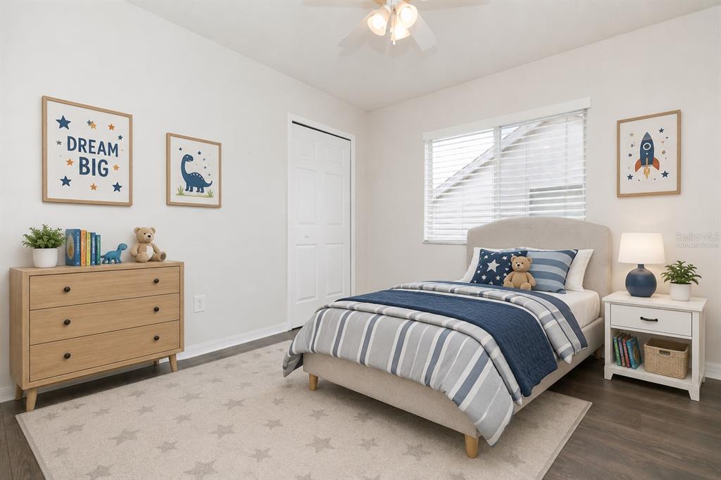 A child's bedroom features a twin bed, a wooden dresser, and blue-themed wall art — 28632 SEASHELL COURT, WESLEY CHAPEL, FL