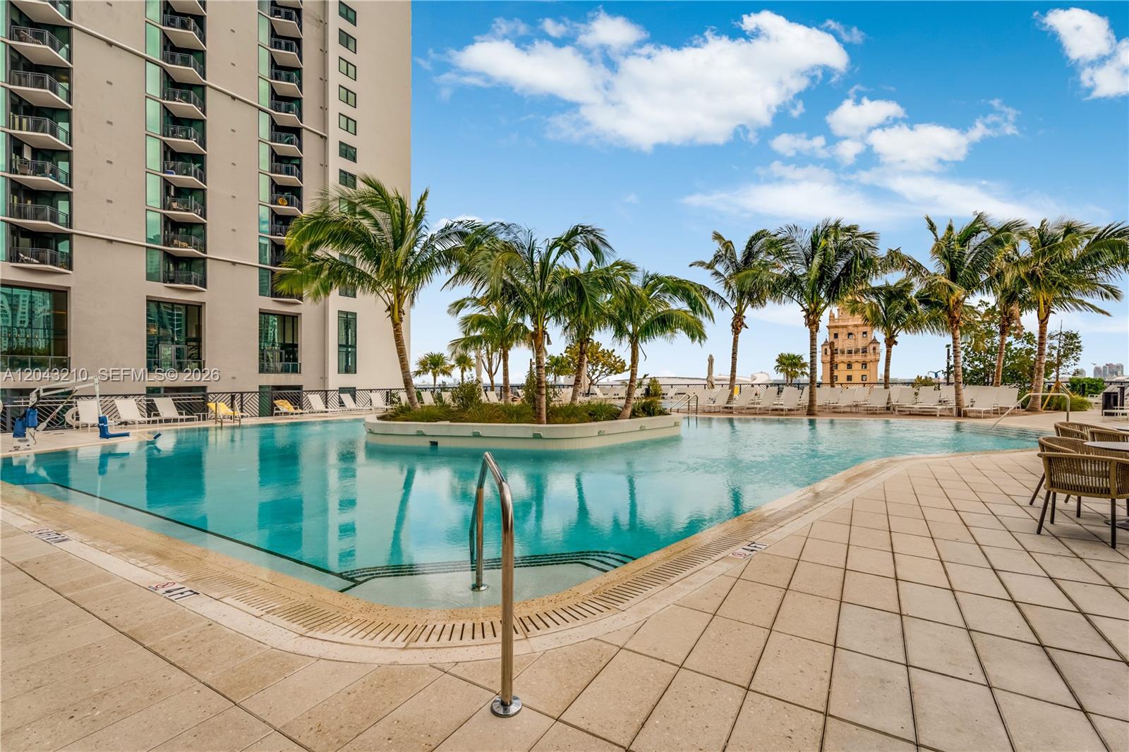 A swimming pool with a central palm tree island sits beside a high-rise building — 159 NE 6th St # 4212, Miami FL 33132, MIAMI, FL