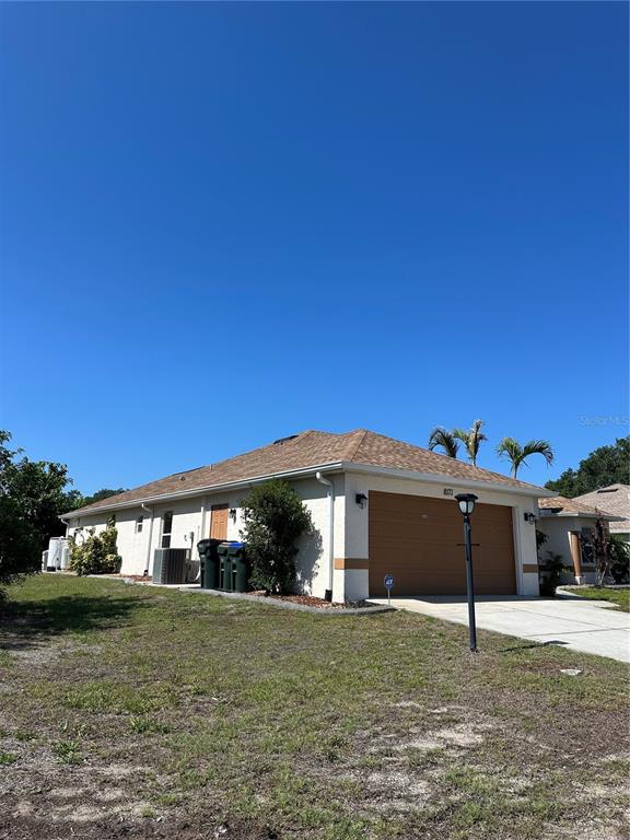A single-story house with a tan exterior, brown roof, and a two-car garage — 8171 ROCLIFF AVENUE, NORTH PORT, FL