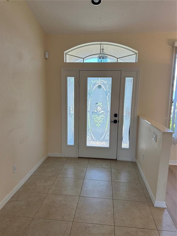 An entryway features a white front door with decorative glass panels and a tiled floor — 8171 ROCLIFF AVENUE, NORTH PORT, FL