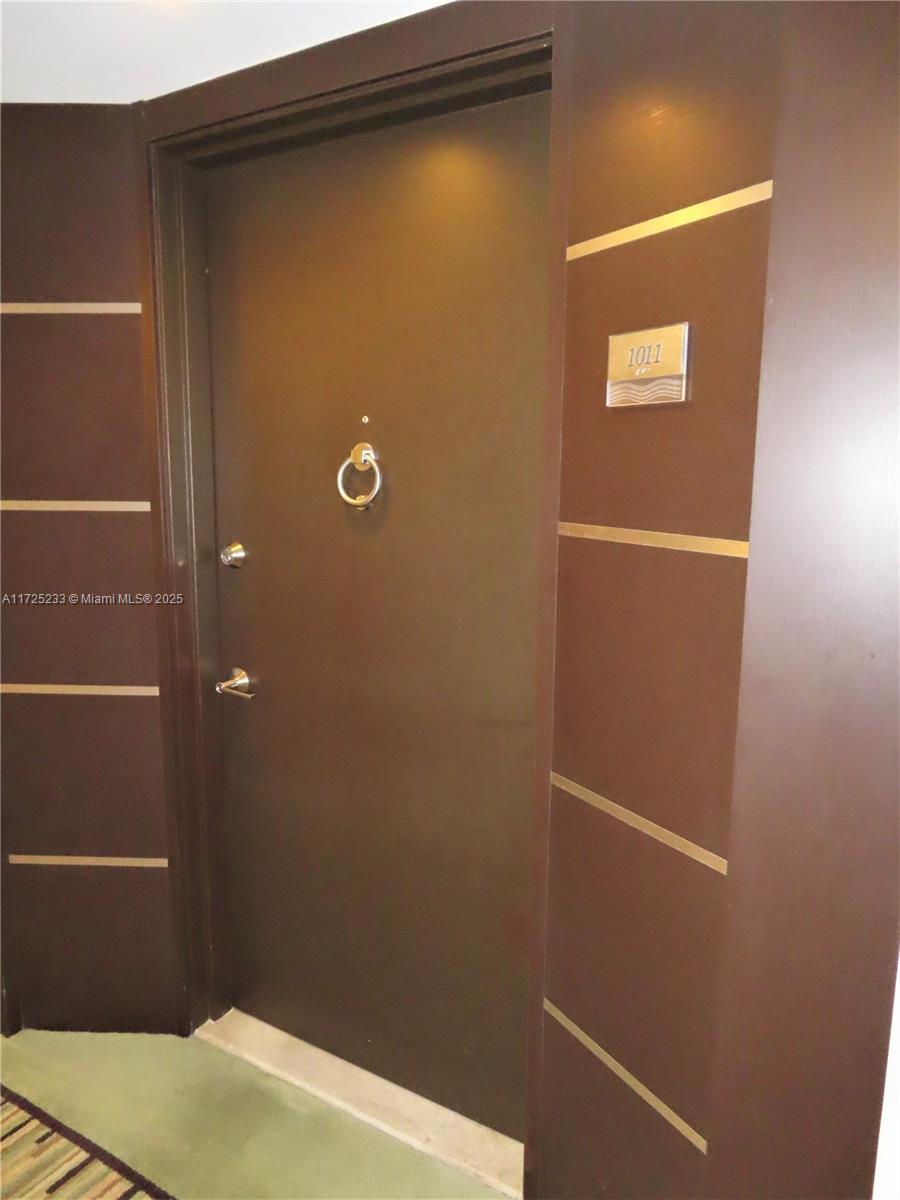 A dark brown door with a gold knocker and room number 1011 — 5701 Collins Ave # 1011, Miami Beach FL 33140, MIAMI BEACH, FL