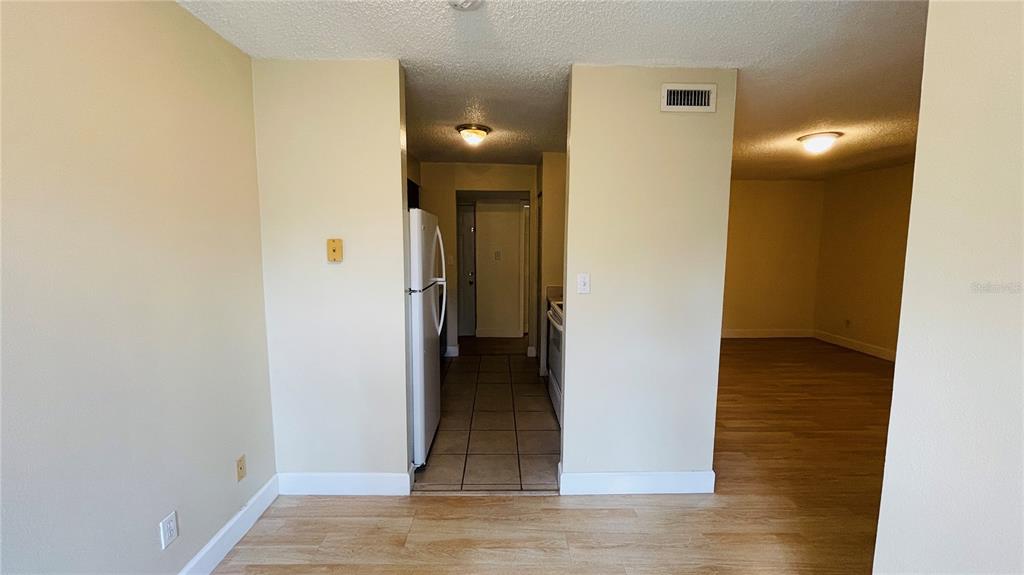 A view from a living area looking into a kitchen with tile flooring and appliances — 7504 NEEDLE LEAF PLACE UNIT 68, TAMPA, FL