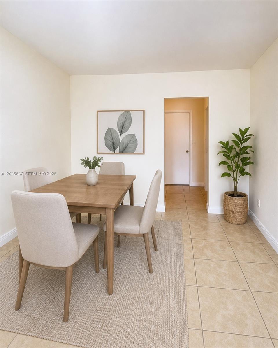 A dining area features a wooden table, four upholstered chairs, a rug, and a potted plant — 1533 NW 2nd Ave # 6, Miami FL 33136, MIAMI, FL