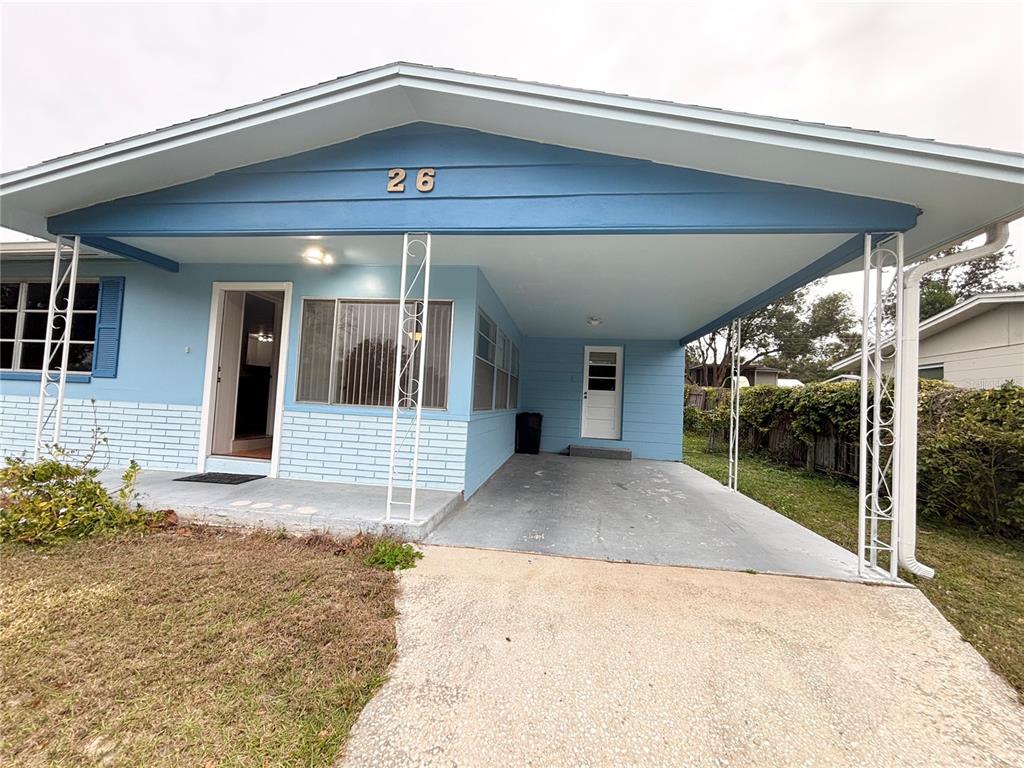 A light blue single-story house features a front carport, brick siding, and a concrete driveway — 26 S OSCEOLA STREET, BEVERLY HILLS, FL