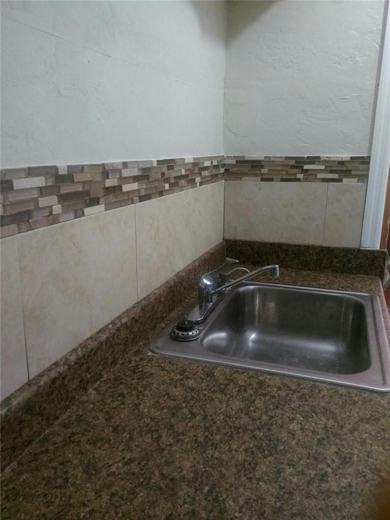 A kitchen sink with a chrome faucet set into a brown speckled laminate countertop — 6764 AZALEA Drive, Miramar FL 33023, MIRAMAR, FL