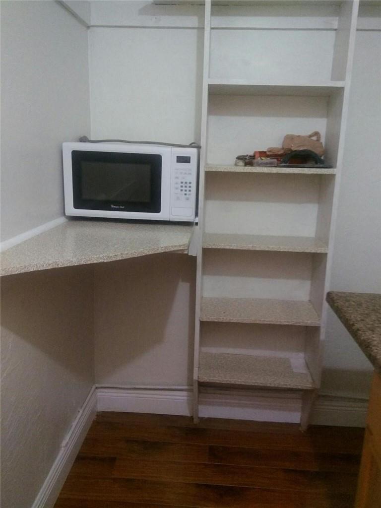 A kitchen corner featuring a microwave on a counter next to a tall shelving unit — 6764 AZALEA Drive, Miramar FL 33023, MIRAMAR, FL
