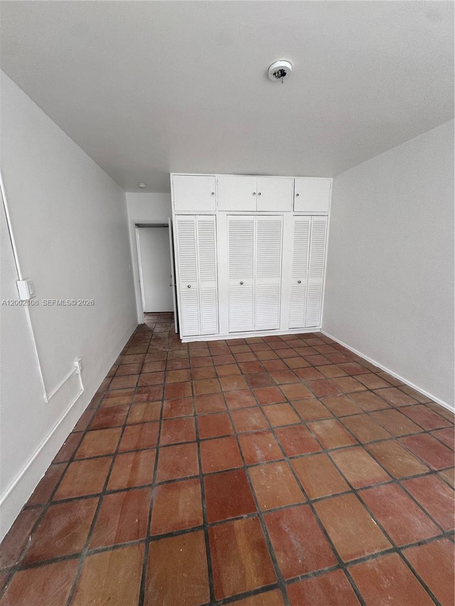 A room with white walls, a built-in white closet unit, and terracotta tile flooring — 10281 E Bay Harbor Dr # C2, Bay Harbor Islands FL 33154, BAY HARBOR ISLANDS, FL