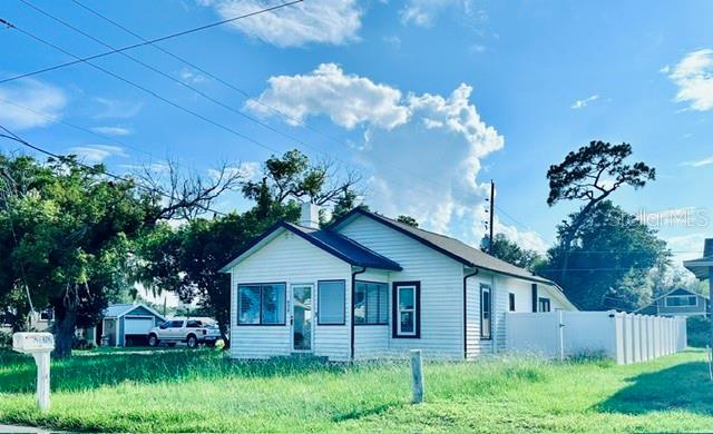 A white, single-story house with a gabled roof stands on a grassy lot — 624 ILLINOIS AVENUE, ST CLOUD, FL