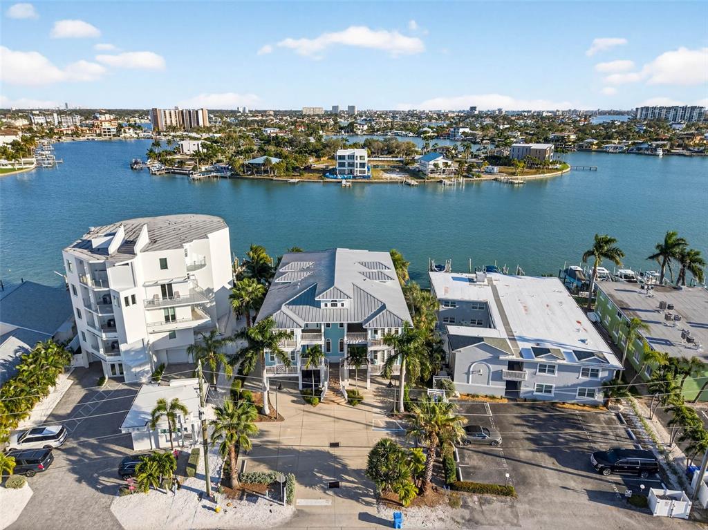 An aerial view shows three waterfront buildings with parking lots and palm trees — 255 104TH AVENUE, TREASURE ISLAND, FL