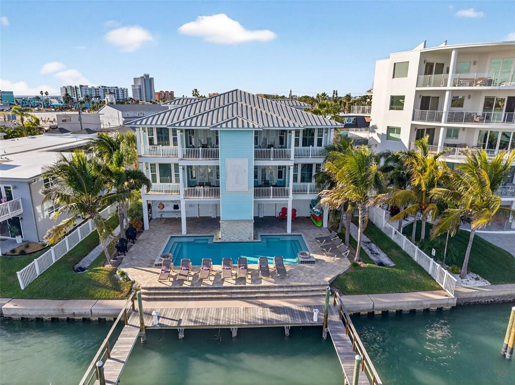 An aerial view of a three-story coastal house with a pool and private dock — 255 104TH AVENUE, TREASURE ISLAND, FL