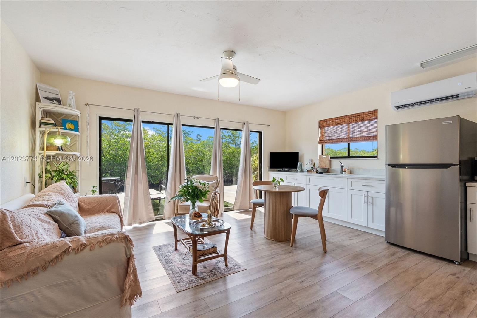 A living room and kitchenette area features a sofa, dining table, and sliding glass doors — KEY LARGO, FL