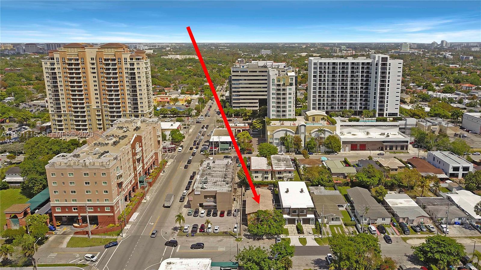 An aerial view shows a low-rise building marked by a red arrow in a city — 3191 SW 23rd St, Miami FL 33145, MIAMI, FL