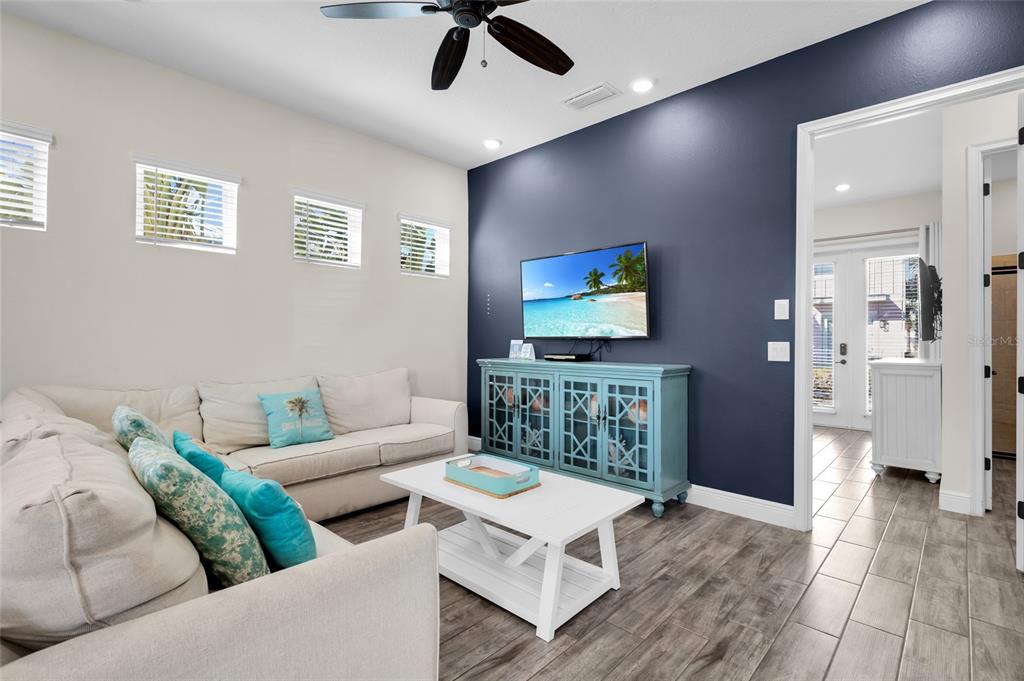 A living room features a blue accent wall, a light-colored sofa, and a white coffee table — 2972 SALTED RIM ROAD, KISSIMMEE, FL