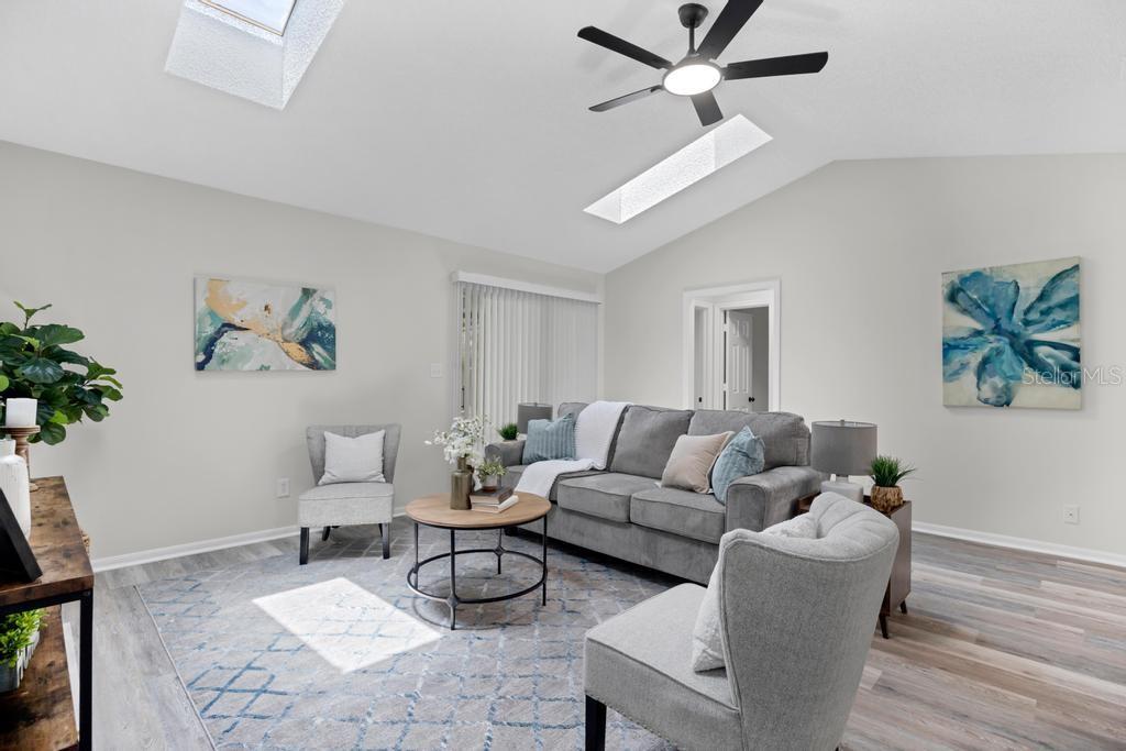 A living room features a gray sofa, two armchairs, a coffee table, and skylights — 6109 W 1ST MANOR, PALATKA, FL