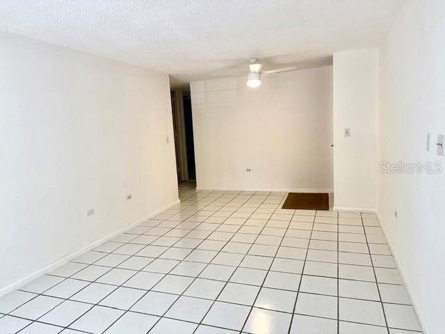 An empty room features white walls, a white ceiling fan, and white tiled flooring — 5870 JOSE TARTAK STREET UNIT B1, CAROLINA, PR