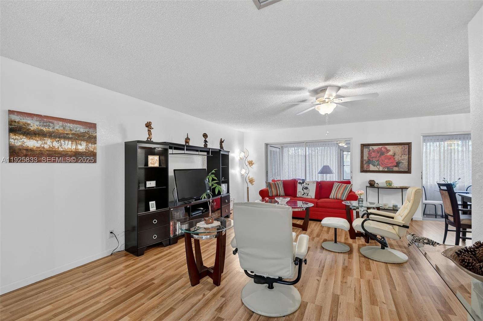 A living room features wood-look flooring, a red sofa, and a black entertainment center — 820 Salem Ln # B, Lake Worth FL 33467, LAKE WORTH, FL