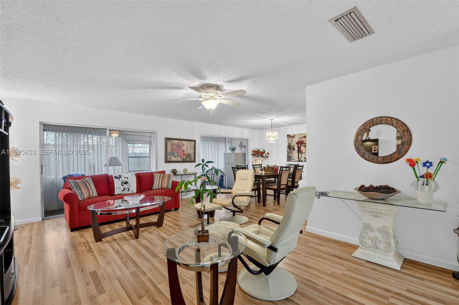 A living and dining room features a red sofa, light-colored recliners, and wood-look flooring — 820 Salem Ln # B, Lake Worth FL 33467, LAKE WORTH, FL