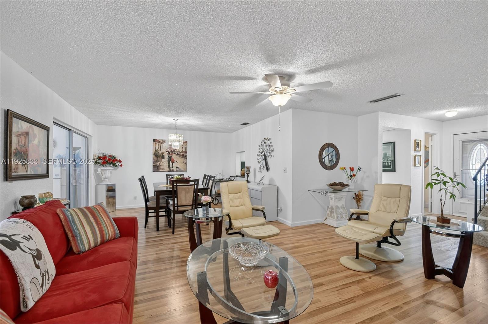 A living and dining area features white walls, wood-look flooring, and a red sofa — 820 Salem Ln # B, Lake Worth FL 33467, LAKE WORTH, FL