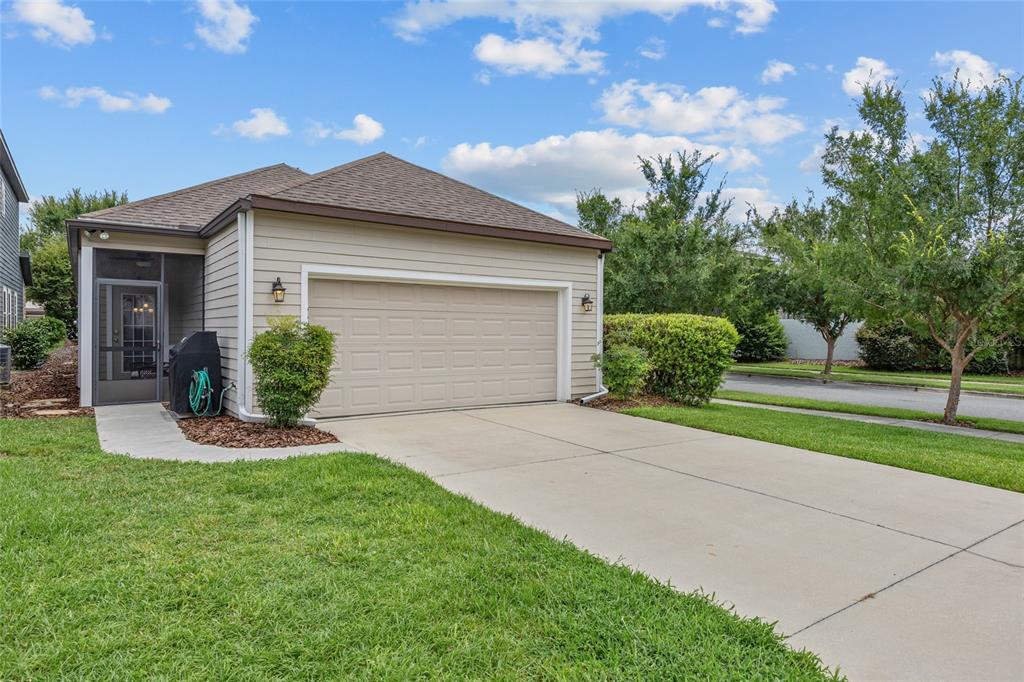 A beige single-story house with a two-car garage and a screened-in front entryway — 8251 SW 78TH LANE, GAINESVILLE, FL