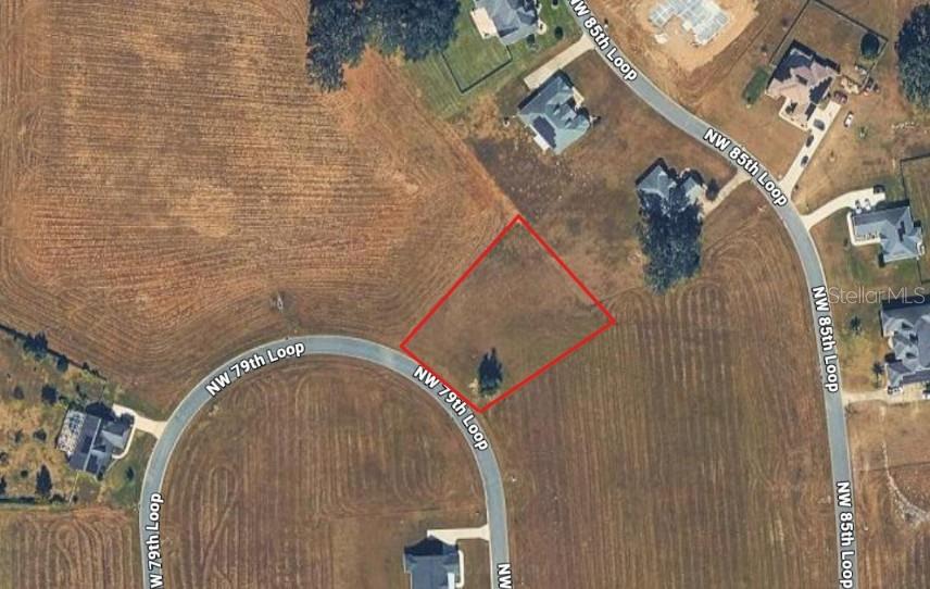 This aerial map shows a vacant, rectangular residential lot outlined in red along a curved road — NW 79TH LOOP, OCALA, FL