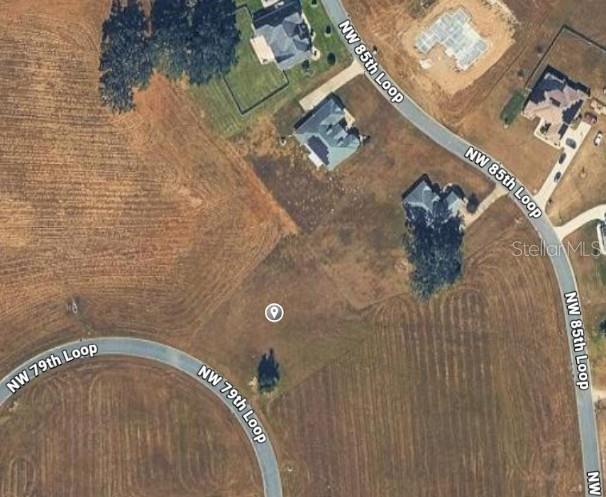 This is an aerial map view of a vacant residential lot surrounded by paved roads — NW 79TH LOOP, OCALA, FL