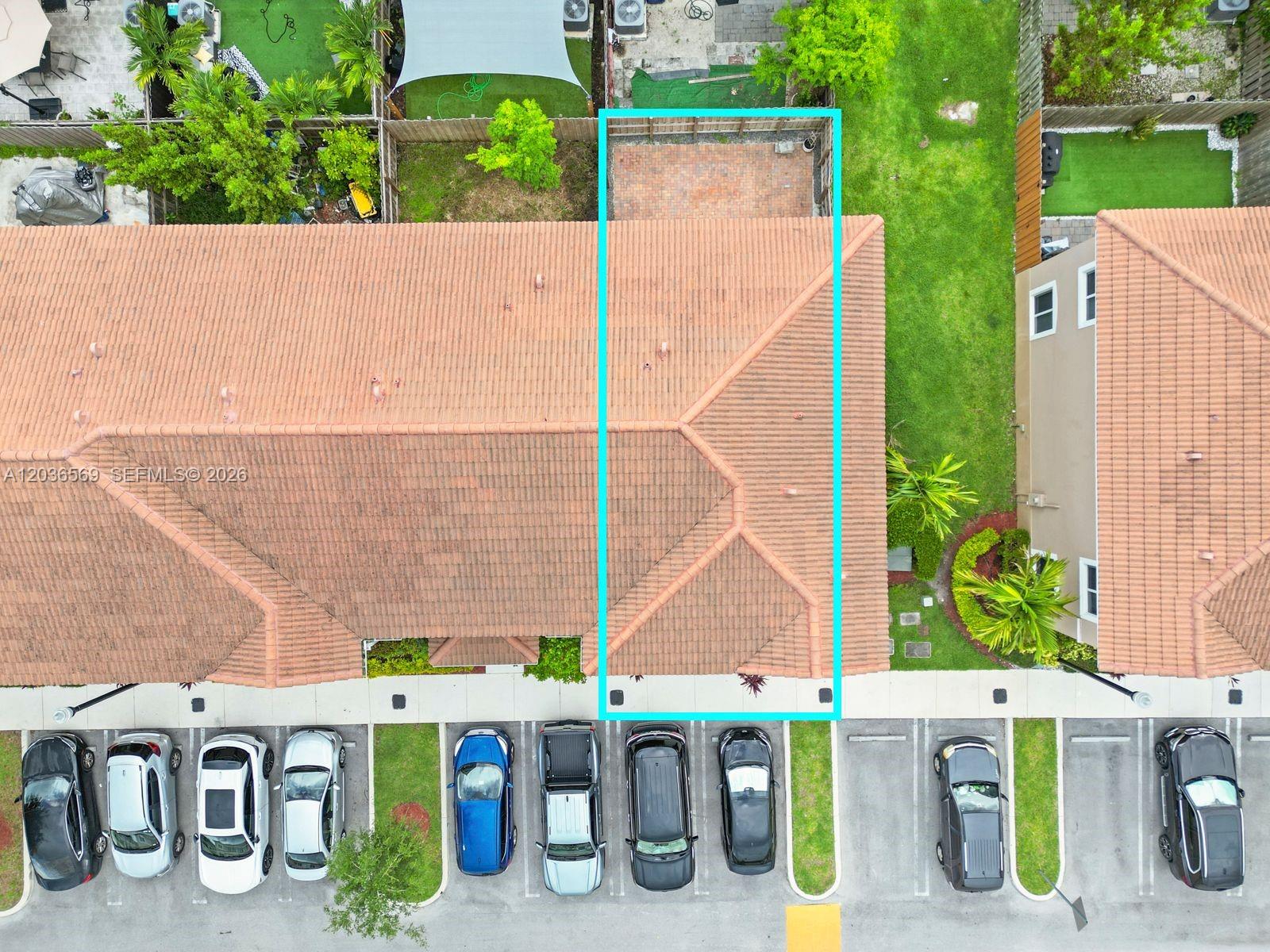 An aerial view shows a townhouse with a fenced brick patio and adjacent parking spaces — 2448 SE 10th Ct, Homestead FL 33035, HOMESTEAD, FL
